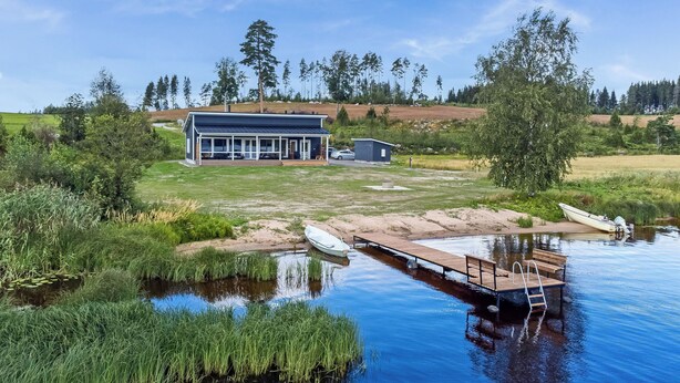 A lakeside property with a dock, a small boat, and a building with a covered patio. - Tervaleppä by Interhome (Ikaalinen)