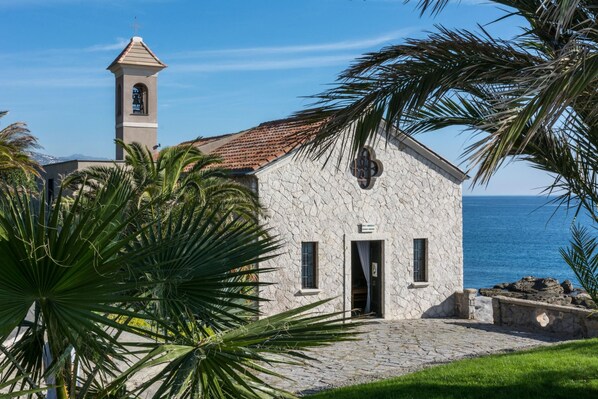 A stone building with a bell tower, a door, and a window. - Il Giardino Sul Mare (Vallecrosia)