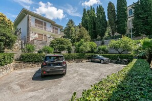 A two-story house with a balcony, parked cars, and a stone wall. - Il Giardino Sul Mare (Vallecrosia)