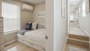 A bedroom with a bed, bedside table, and a window with blinds. - Beautiful Cottage with Water Views - 2 Bedrooms (Delanco)