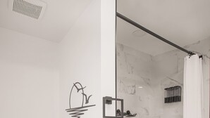 A modern bathroom with a toilet, shower, and bathtub.
