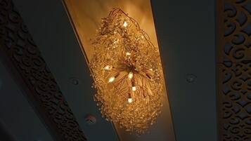 A chandelier with multiple light bulbs hanging from a decorative metal frame.