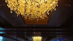 Un hall d’entrée spacieux, orné d’un grand et somptueux lustre suspendu au plafond.
