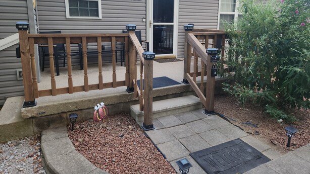 A house with a wooden front porch, a welcome mat, and a small garden area with gravel and plants. - Quiet and sophisticated apartment with AC in Clinton (Clinton)