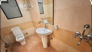 Une salle de bain avec des toilettes, un lavabo et une douche.