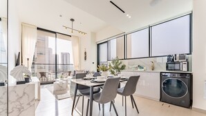 Una cocina moderna con comedor, ventanas amplias y lavadora secadora integradas.