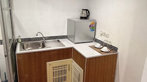 A compact kitchen with a sink, a small refrigerator, and a coffee maker. - Moonlight Bar and restaurant  (Koh Samui)