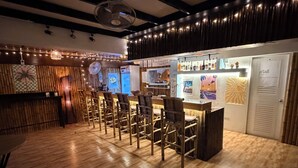 A bar area with wooden chairs and a counter. - Moonlight Bar and restaurant  (Koh Samui)