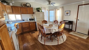 A kitchen with wooden cabinets, a microwave, and a dining table with chairs. - Family Getaway in Interior, SD – Just 5 Min to Badlands NP (Interior)