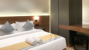 A hotel room with a neatly made bed, a bedside table with a lamp, and a built-in wardrobe. - Arjan Park Apartments (Riyadh)