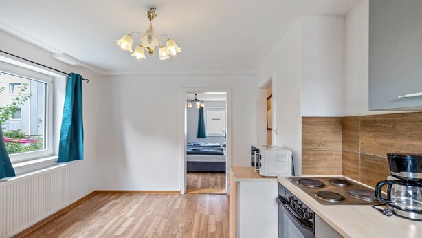 A modern kitchen with a stove, microwave, and coffee maker. - Apartment 'Yellow A' (Miltenberg)
