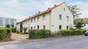 A two-story residential building with a red-tiled roof, multiple windows, and a paved driveway. - Apartment 'Yellow A' (Miltenberg)