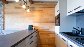 Uma cozinha moderna com piso de madeira, armários brancos e bancada de granito.