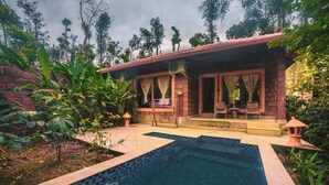 A house with a swimming pool, surrounded by lush greenery and a brick wall. -  Copper Edge – Eco Resort, Coorg  (Shanivarsanthe)