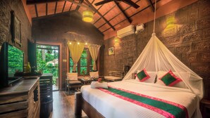 A room with a bed, wooden furniture, and a stone wall. -  Copper Edge – Eco Resort, Coorg  (Shanivarsanthe)