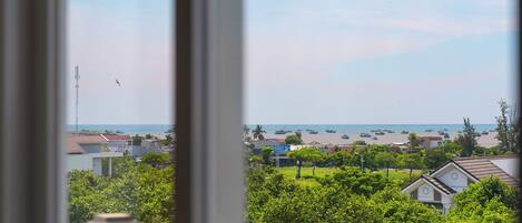 A coastal view with buildings, greenery, and the sea.
