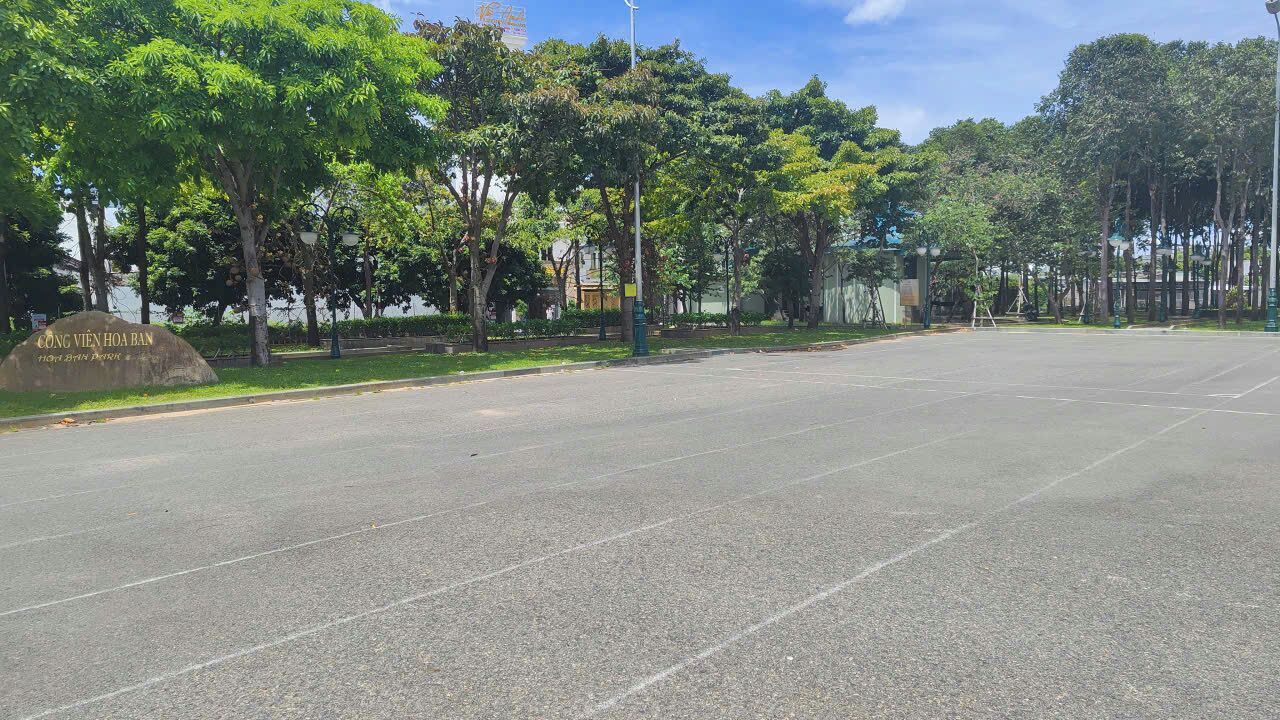 A parking lot with trees and a sign that reads "VNG VIEN HOA BAN."