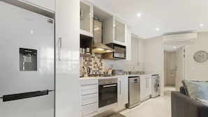 Una cocina compacta equipada con refrigerador, microondas, horno y lavavajillas.