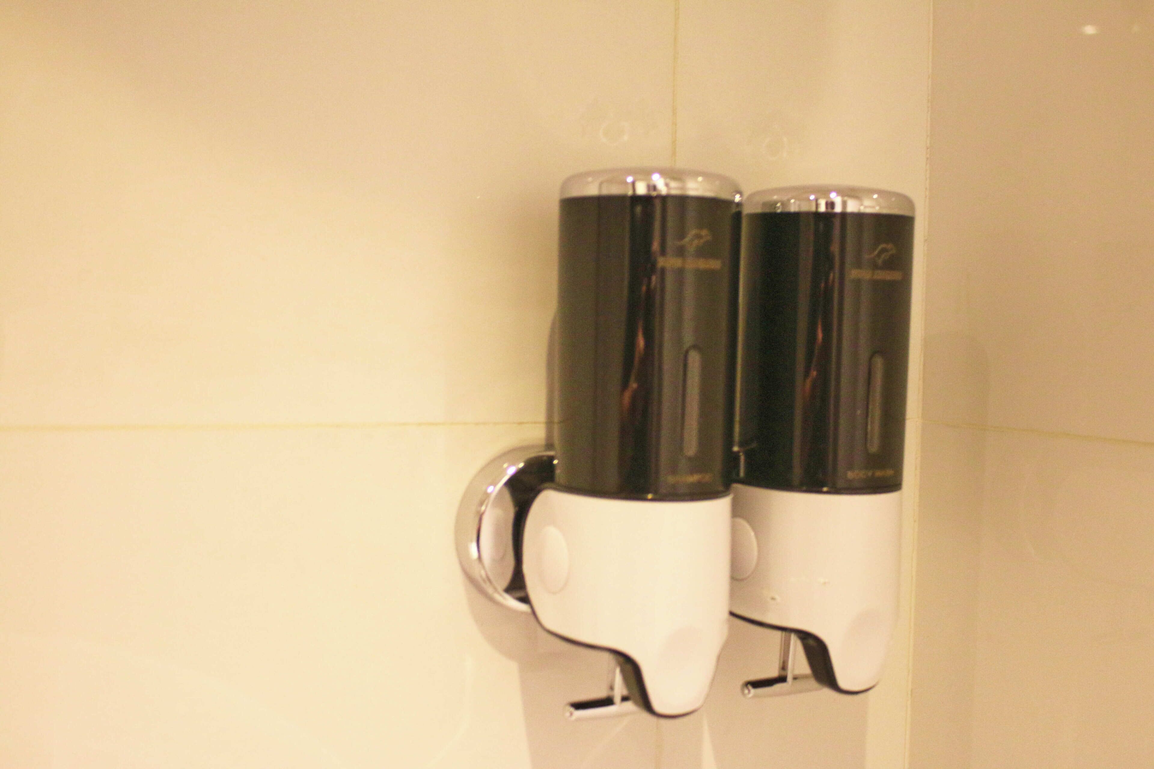 A restroom with two hand dryers mounted on a wall.