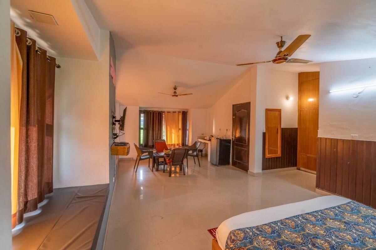 A hotel room with a bed, a dining area, and a kitchen.