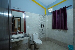 Une salle de bain avec un lavabo, des toilettes et une douche.