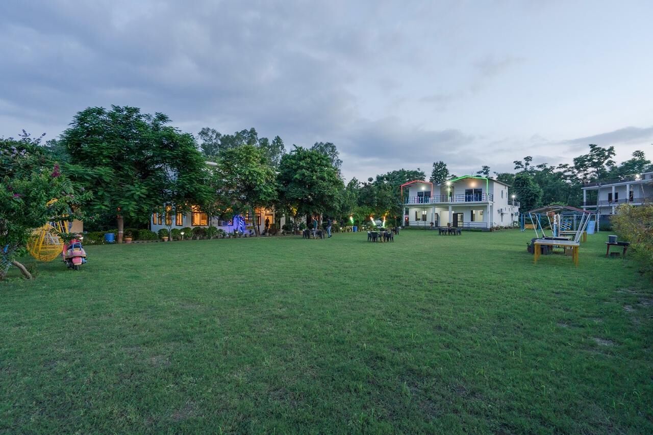 A spacious grassy area with a building featuring multiple balconies and a staircase.