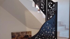 Un escalier avec une rampe noire ornée de motifs de feuilles.