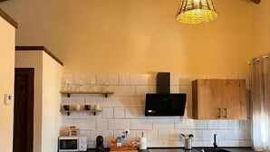 Une cuisine compacte avec des meubles en bois, un four à micro-ondes, un évier et un lave-linge.