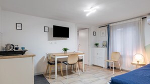 A compact room with a bed, a desk, a chair, a television, and a small cabinet. - GuestHost - Central apartment Caronda Compact (Catania)