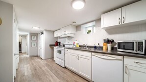 Eine moderne Küche mit weißen Schränken, einer Edelstahl-Mikrowelle und einem eingebauten Backofen.