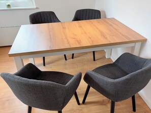 A rectangular wooden table with four dark grey chairs.
