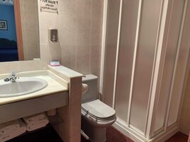 Un baño con lavamanos, inodoro y dispensador de gel antibacterial.
