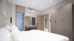 A bedroom with a bed, a bedside table, a mirror, and a wardrobe. - Manazel Marez 2 - private apartments (Madinah)