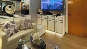 Una sala de estar moderna con sofá, mesa de centro y televisor.