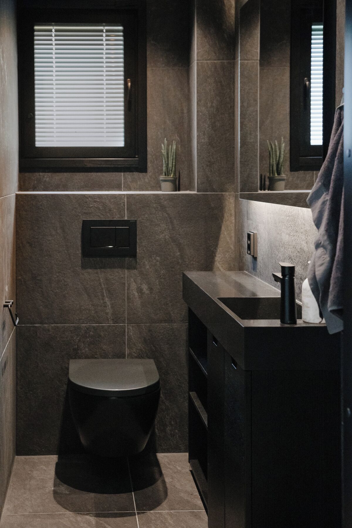 A modern bathroom with a toilet, a sink, and a mirror.