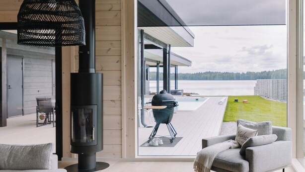 Un salon moderne avec une grande fenêtre, une cheminée, un canapé et une table basse.