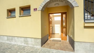 A building entrance with a stone archway, a door, and a small window.