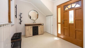 A hallway with a wooden door, a mirror, a cabinet, and a radiator. - Double D Modern Family Apartment Near Koper (Koper)