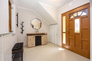 A hallway with a wooden door, a mirror, a cabinet, and a radiator. - Double D Modern Family Apartment Near Koper (Koper)