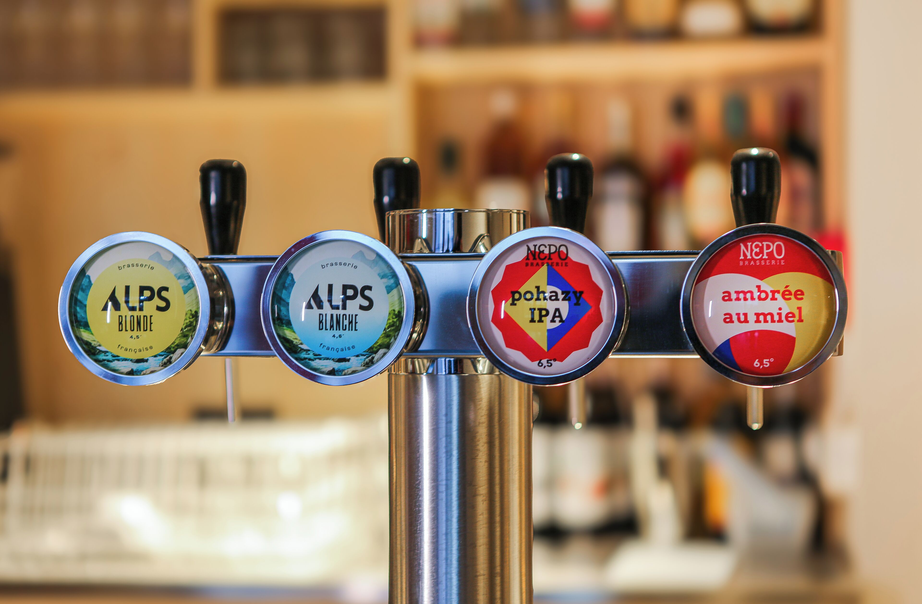A beer tap with four different beer options: Alps Blonde, Alps Blanche, Pahazy IPA, and Neppo Ambrée au miel.