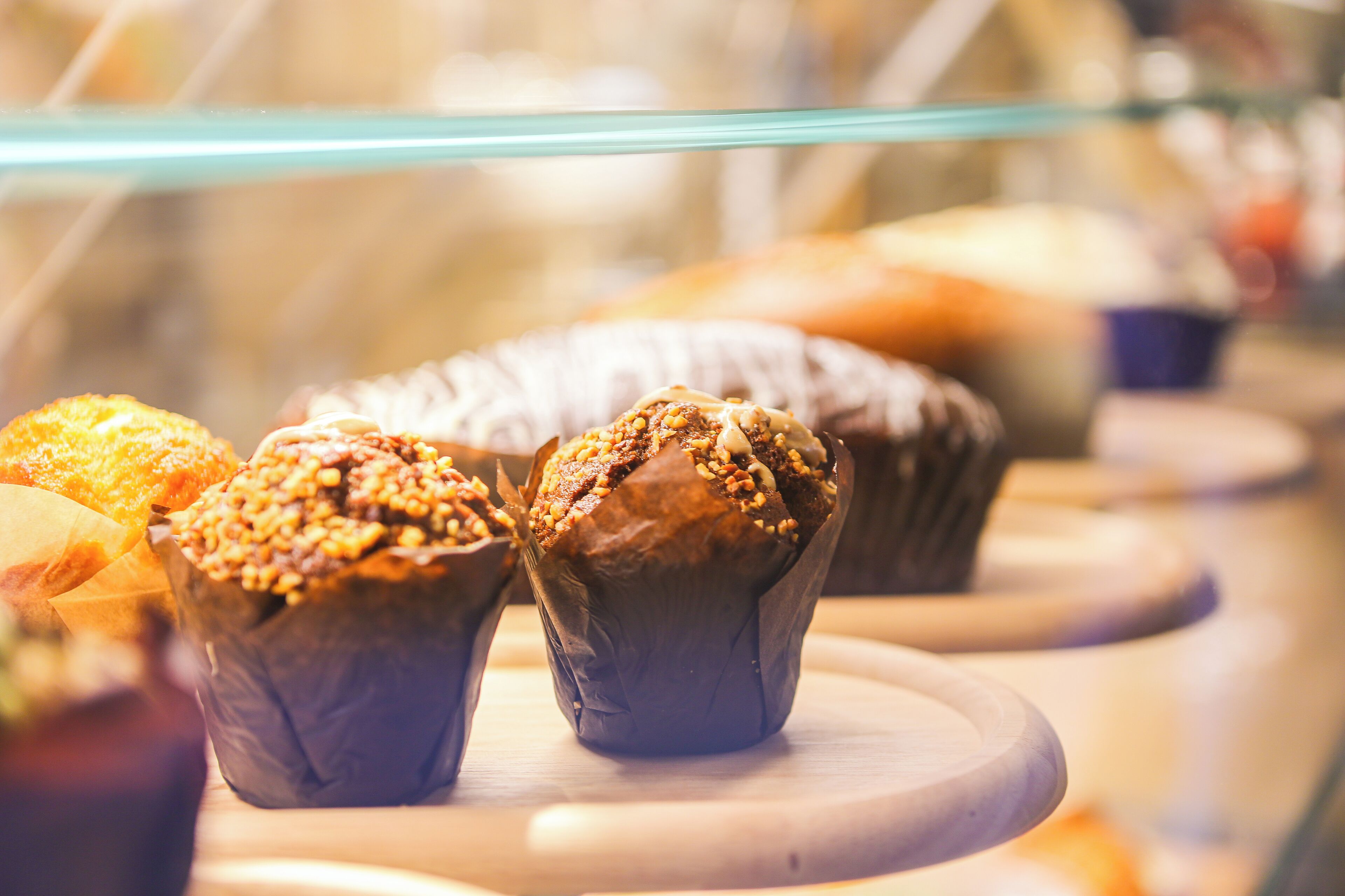Une vitrine contenant divers produits de boulangerie, notamment des muffins et des pâtisseries.