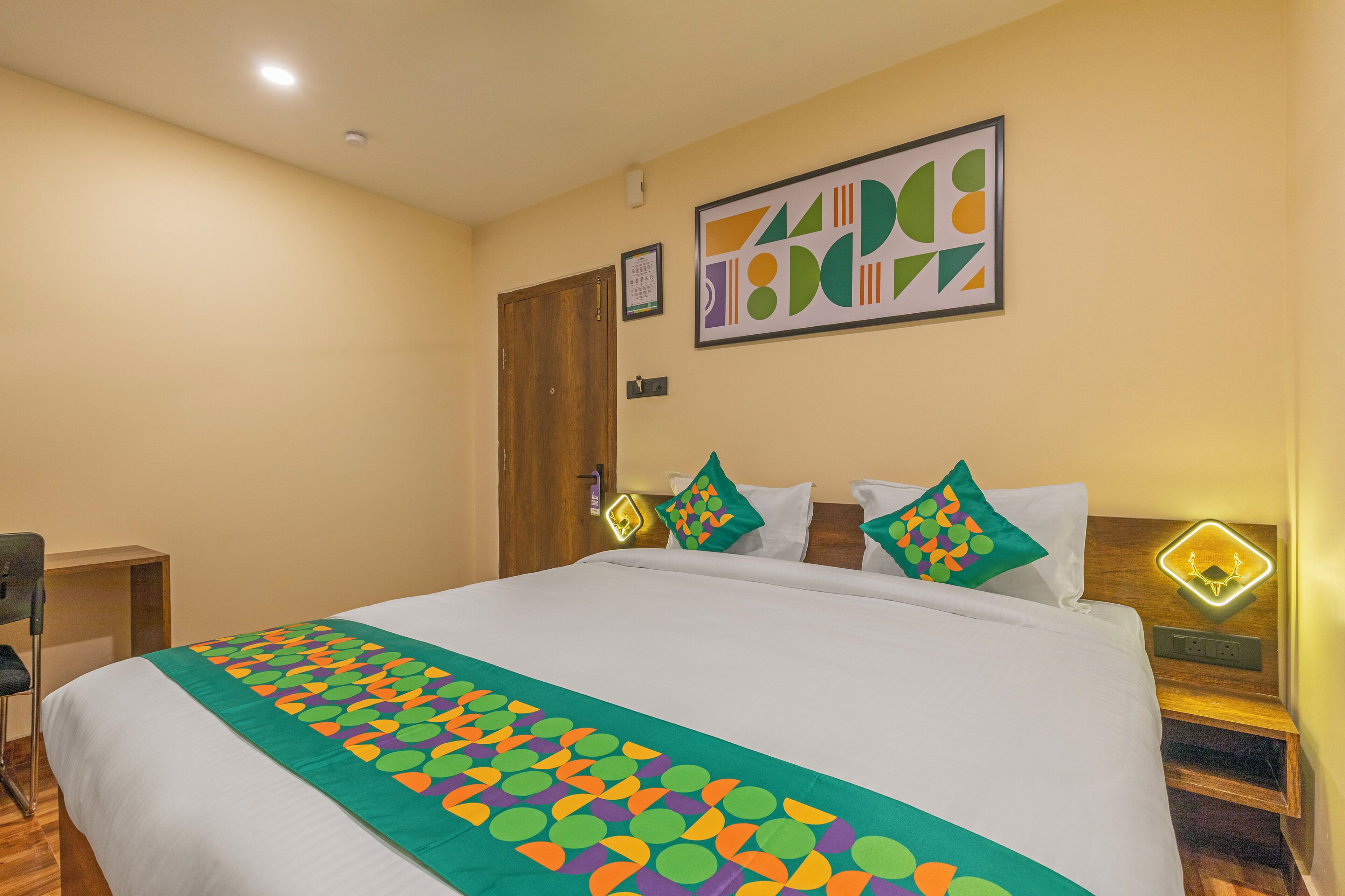 A hotel room with a bed, a desk, and a chair.