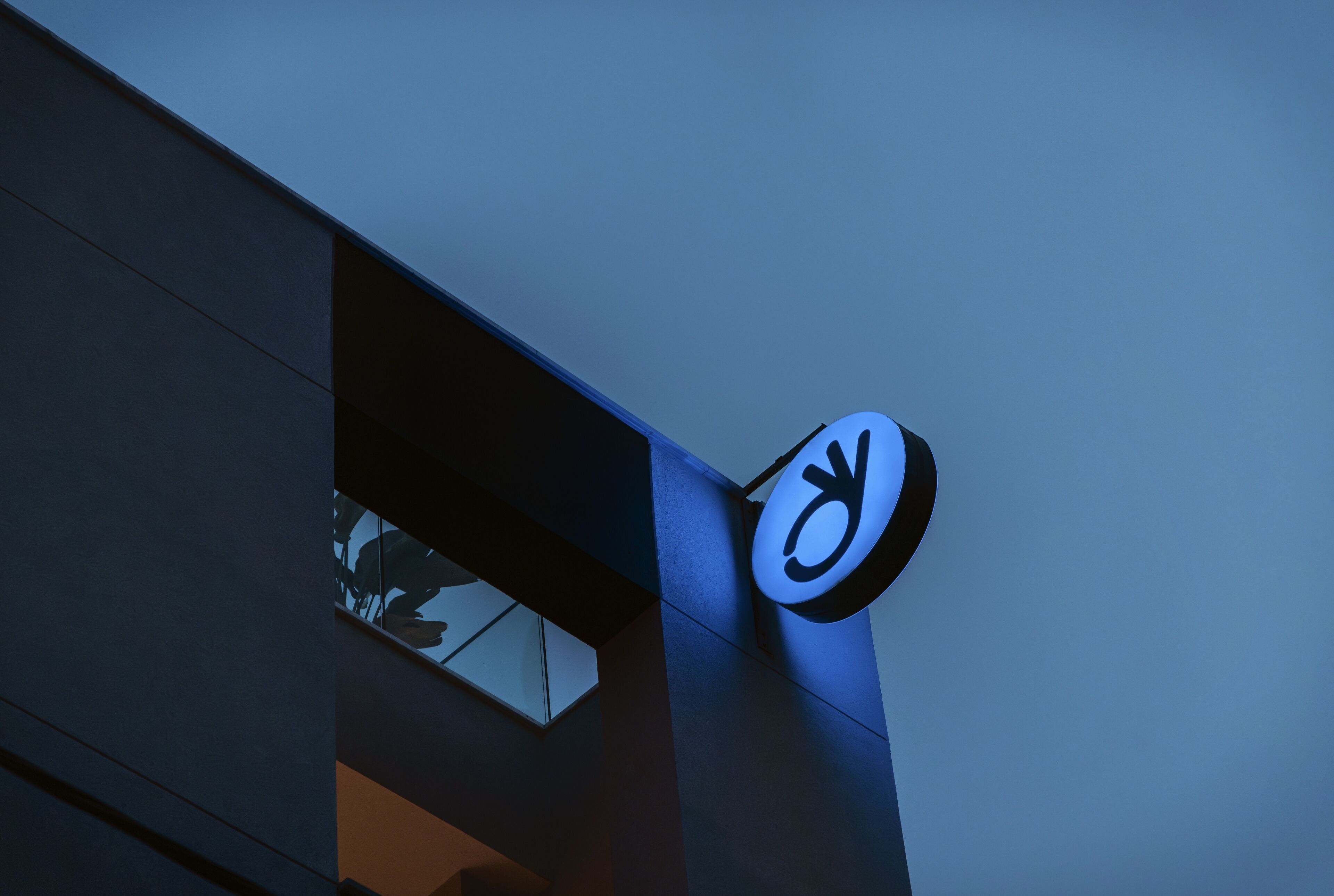 Un bâtiment sur lequel on peut voir une enseigne ornée d’un symbole stylisé.
