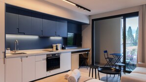 Eine moderne Küche mit Einbauofen, Spüle und Essbereich mit Tisch und Stühlen.