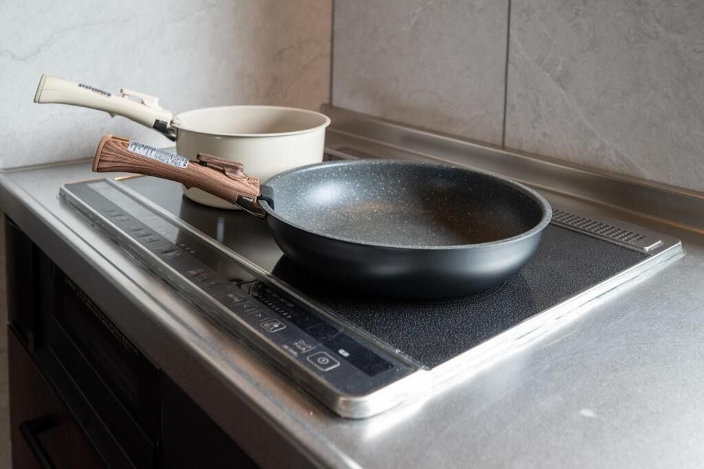 Una cocina con estufa, sartén y olla.