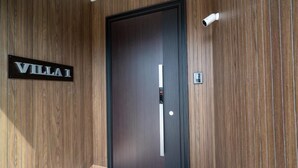 A wooden-paneled hallway with a door labeled "VILLA 1". - Furano Torinuma VILLA (Furano)
