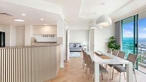 Eine moderne Wohnung mit Küche, Essbereich und einem Balkon mit Stadtblick.