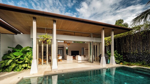 A modern house with a swimming pool, covered patio, and lush greenery. - Exclusive villa in Botanica The Nature (Choeng Thale)