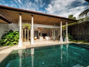 A modern house with a swimming pool, covered patio, and lush greenery. - Exclusive villa in Botanica The Nature (Choeng Thale)