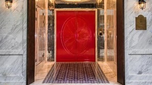 A hotel entrance with a red door, illuminated signage, and marble walls. - Tung Nam Lou Art Hotel (Kowloon)